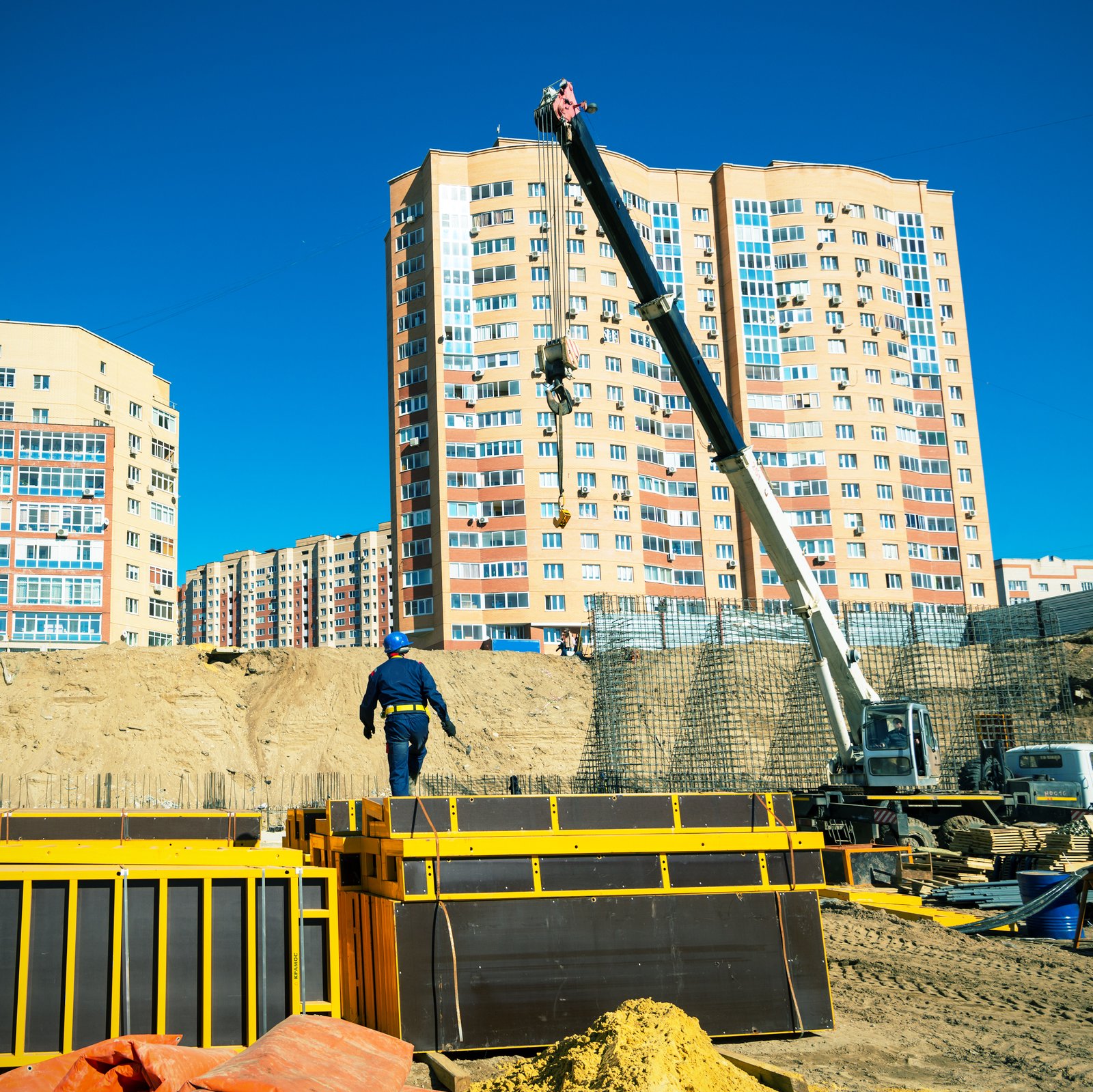 Crane and worker working on a construction site.